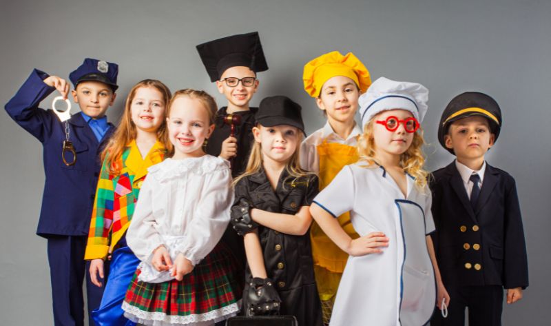 Kinder in verschiedenen Kostümen wie Polizist, Koch, Pilot und Ärztin – perfekte Inspiration für eine Schnitzeljagd-Story mit Verkleidung. Ideal für eine kreative Schatzsuche, bei der Rollen und Abenteuer eine besondere Rolle spielen. 